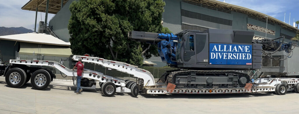 Alliance Diversified drill rig loaded on lowboy trailer for equipment transport