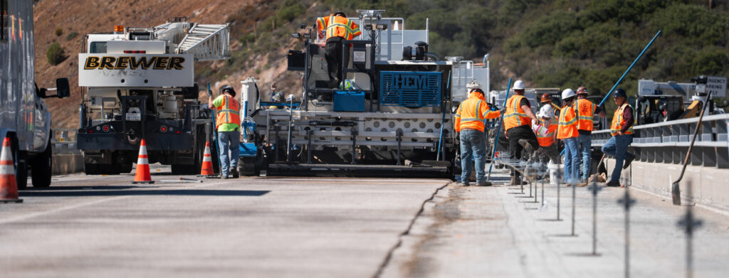 Crew installing polyester concrete overlay on bridge deck