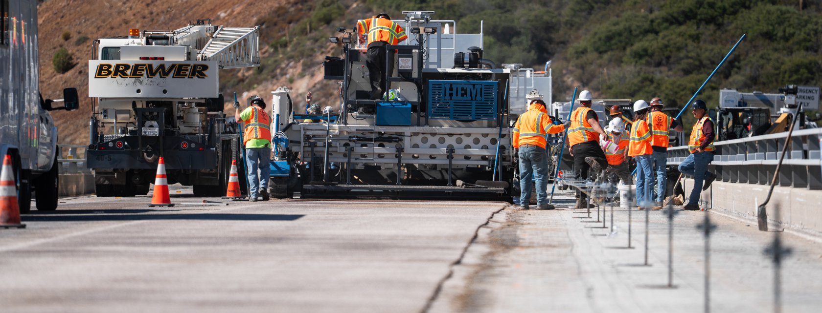 Crew installing polyester concrete overlay on bridge deck