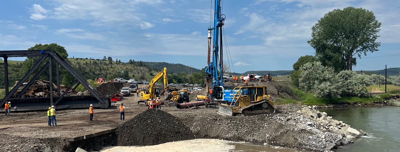 Geotechnical drilling rig operating near river crossing and bridge structure