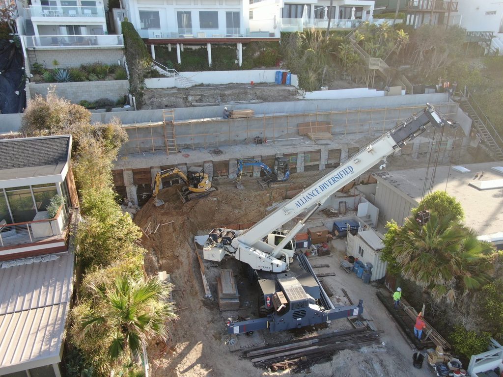 Caisson, shotcrete and wood lagging shoring & excavation with the crane positioned on the jobsite.
